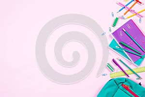 School stationery on pink background with copyspace