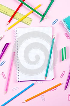 School stationery on pink background with copyspace