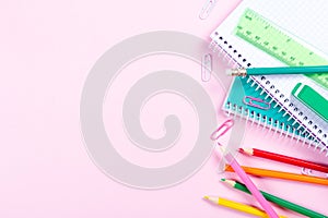 School stationery on pink background with copyspace