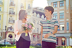 School student congratulates his teacher with bouquet of flowers. Teacher`s Day.