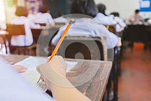 School student`s taking exam writing answer in classroom for education and literacy