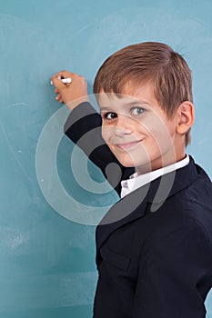 School student writing on blackboard at school