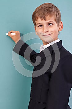School student writing on blackboard at school