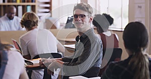 School student writing classroom test, learning and reading in notebook or book for exam with other high school students