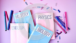 School subject books with supplies on color background, back to school. Stationery ruler pencil paper clips