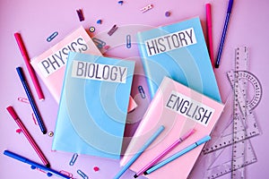 School subject books with supplies on color background, back to school. Stationery ruler pencil paper clips