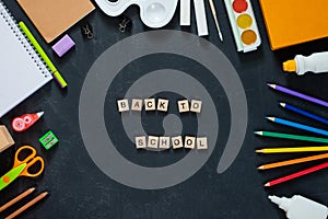 School supplies on black board background. Back to school concept. Frame, flatlay, copy space for text.