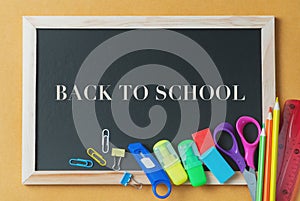 School supplies on black board background. Back to school concept