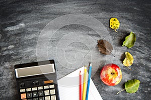 School supplies on black board background. Color pencils, calculator, rules and copybooks. Back to school concept. 1of September