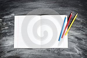 School supplies on black board background. Color pencils and copybooks. Back to school concept. 1of September