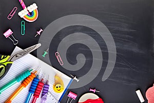 School supplies on black board background with copy space. Back to school
