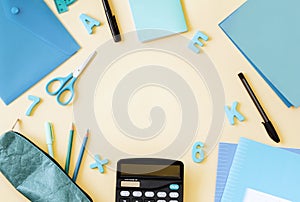 School supplies are blue and black with a space for text in the center. Pen, pencil case, calculator, notebook, notepad