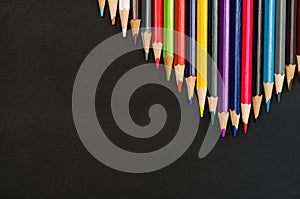 School supplies border on black chalkboard background. Top view photograph