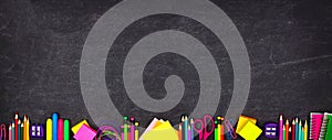 School supplies bottom border banner, top view on a chalkboard background with copy space. Back to school.