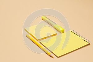 School supplies. Color pencils, notebook, note-paper and felt pen on beige background