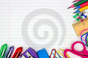 School supplies corner border on lined paper background