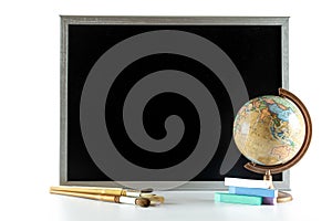 School supplies. Education accessories with colorful pencils, chalk, globe on dark school blackboard. Concept for Teachers Day,