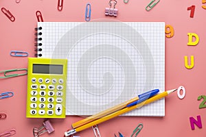 School supplies and empty notepad white sheet of paper with yellow calculator on copy space background