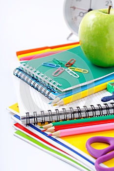 School supplies with green apple and alarm clock