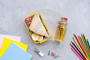 School supplies and lunch box with sandwich and vegetables. Back to school. Healthy eating habits concept - background layout with