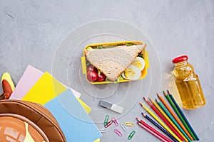 School supplies and lunch box with sandwich and vegetables. Back to school. Healthy eating habits concept - background layout with