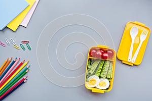 School supplies and lunch box with sandwich and vegetables. Back to school. Healthy eating habits concept - background layout with