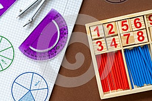 School supplies, math fractions, pencils, numbers, on brown background. Back to school, education concept background.