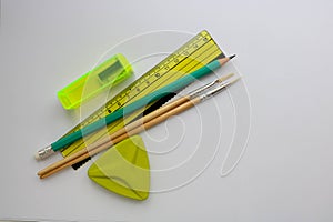 School supplies ruler, pencil, sharpener, eraser, brushes.