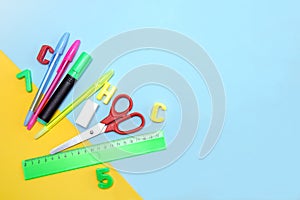 school supplies - ruler, pens, eraser, numbers and letters, scissors, marker on a yellow-blue background with copy space