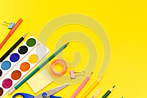 School supplies stationery on yellow background. View from above