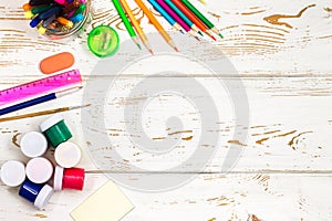 School supplies on a white wooden background with an empty space for inscriptions.