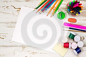 School supplies on a white wooden background with an empty space for inscriptions.