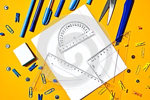 School supplies on yellow background, copy space, scissors, pen, paper clips, ruller, stickers. Back to school