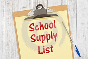 School supply List message on yellow lined paper with a pen on a clipboard