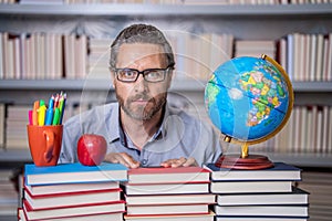 school teacher with book in classroom. teacher in classroom. Teachers Day. Tutor at classroom. Man geographer with books