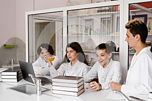 School teacher gives chemistry lesson to children in a laboratory with flasks with liquids for experiments. Education