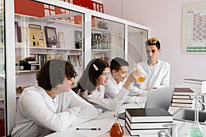 School teacher gives chemistry lesson to children in a laboratory with flasks with liquids for experiments. Education