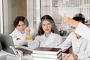 School teacher gives chemistry lesson to children in a laboratory with flasks with liquids for experiments. Education