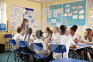 School teacher and kids work on class project, low angle