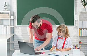 School teacher with a schoolboy learning at laptop computer, studying with online education e-learning. Teacher and