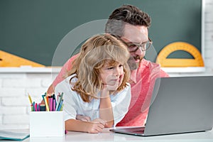 School teacher with a schoolboy learning at laptop computer, studying with online education. Teacher and students in the