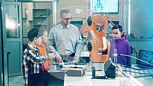 School teacher with students work with robot in a school lab
