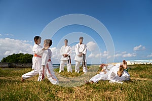 School Teachers And Children At Karate Lesson Near The Sea
