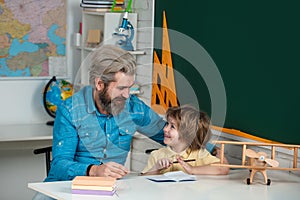 After school teaching. School kids. Funny little child with father having fun on blackboard background. Early