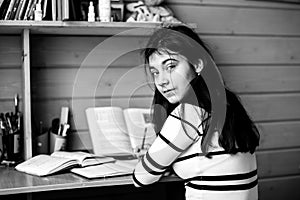 School teengirl doing homework sitting at the table in the room. Black and white photo.