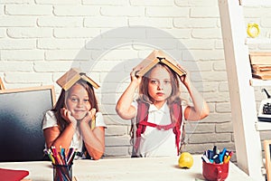 School time of girls. Friendship of small sisters in classroom at knowledge day. Back to school and home schooling. sad photo