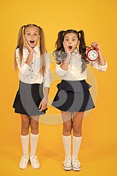 School time. Surprised shocked kids hold alarm clock counting time. Latecomer will be punished. It is time. School