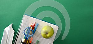 School tools with paper plane and apple on green panoramic