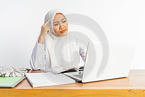 school veiled girl at desk having problem while using laptop