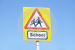 School warning sign blue sky red triangle road safety children young kids parent